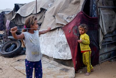 Displaced Palestinian girls stand outside a tent in Gaza city. Reuters
