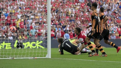 Arsenal defender Laurent Koscielny scores his team's second goal past Hull City goalkeeper Allan McGregor during the FA Cup final on Saturday. Adrian Dennis / AFP / May 17, 2014