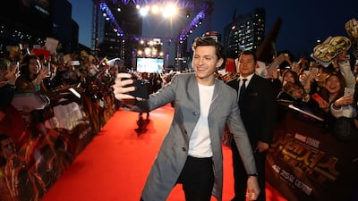 Tom Holland, in grey coat and black trousers, attends the Seoul 'Avengers Infinity War' premiere on April 12, 2018. Getty Images