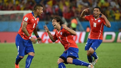Chile's Jorge Valdivia, centre, celebrates with Arturo Vidal after scoring during a Group B match against Australia at the Pantanal Arena in Cuiaba during the 2014 Fifa World Cup on June 13, 2014. William West / AFP