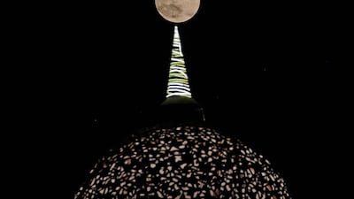 The supermoon appears to be perched on top of the dome of a shopping arcade on the outskirts of New Delhi, India. AFP