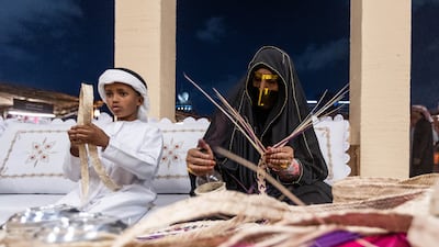Local women demonstrate their crafts for young visitors at Qasr Al Hosn