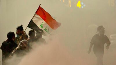 Iraqi demonstrators gather amid smoke from burning tyres during a protest near the governor's residence in the southern city of Basra. AFP
