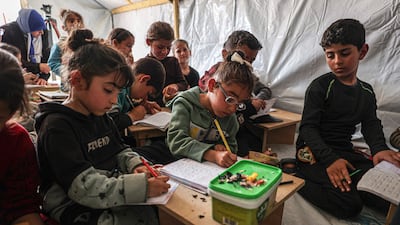 Children attend a lesson at a makeshift classroom in a camp for displaced Palestinians in Rafah, in the southern Gaza Strip. AFP