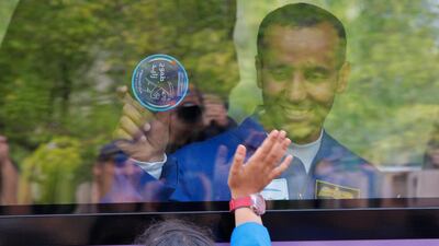 Hazza Al Mansouri waves to relatives from a bus prior to the launch of the Soyuz rocket at 5.56pm. Dmitri Lovetsky / AP Photo
