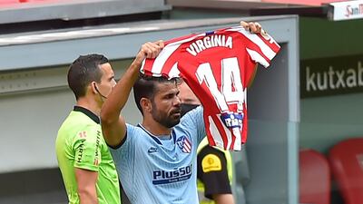 Diego Costa celebrates his goal by holding up a shirt baring the name and number of Virginia Torrecilla - a midfielder for their women's team - who had surgery for a brain tumour. AFP