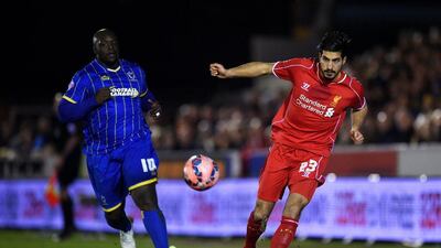 Emre Can of Liverpool controls the ball as Adebayo Akinfenwa of AFC Wimbledon closes in during their FA Cup third round contest. Michael Regan / Getty Images