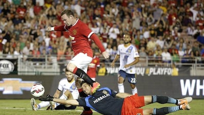 Manchester United's Wayne Rooney dribbles of LA Galaxy keeper Jaime Penedo to score on Wednesday in United's 7-0 international friendly win. AP Photo / July 23, 2014