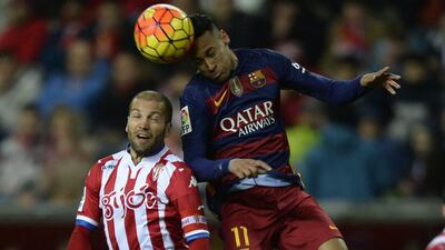 Barcelona’s Brazilian forward Neymar (R) jumps for the ball with Sporting Gijon’s defender Alberto Lora during the Spanish league football match Real Sporting de Gijon vs FC Barcelona at El Molinon stadium in Gijon on February 17, 2016. AFP PHOTO / MIGUEL RIOP