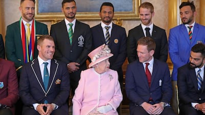 The Queen shares a word with England captain Eoin Morgan as they sit in preparation for a group fixture. AFP