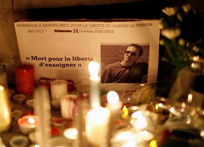 Candles are lit at a makeshift memorial as people gather to pay homage to Samuel Paty, the French teacher who was beheaded on the streets of Paris. Reuters