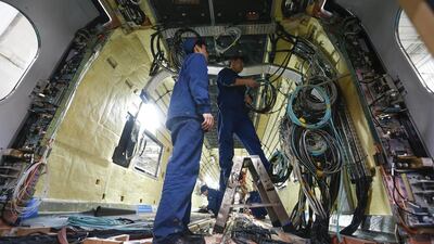 Technicians work on the interior cables of a train car at an assembly plant of the Tangshan Railway Vehicle. Rolex Dela Pena / EPA