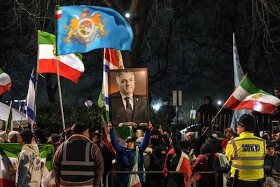 A protester holds up a portrait of Reza Pahlavi outside the Iranian embassy in London. AFP