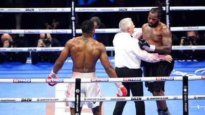 Referee Marcus McDonnell, centre, speaks to Jermaine Franklin, right, during a heavyweight boxing match against Anthony Joshua. AP