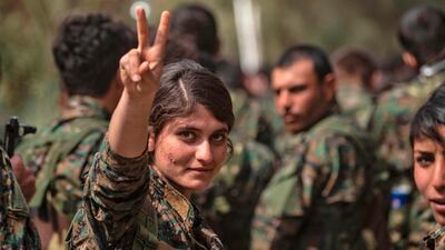 A female fighter of the US-backed Kurdish-led Syrian Democratic Forces (SDF) flashes the victory gesture while celebrating near the Omar oil field in the eastern Syrian Deir Ezzor province after announcing the total elimination of ISIS. AFP