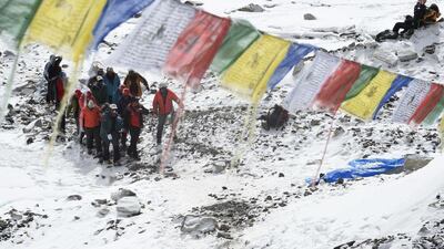 Rescue team personnel carry an injured person towards a waiting rescue helicopter at Everest Base Camp, a day after an avalanche triggered by an earthquake devastated the camp. Rescuers in Nepal are searching frantically for survivors of a huge quake on April 25, that killed nearly 2,000, digging through rubble in the devastated capital Kathmandu and airlifting victims of an avalanche at Everest base camp. Roberto Schmidt / AFP