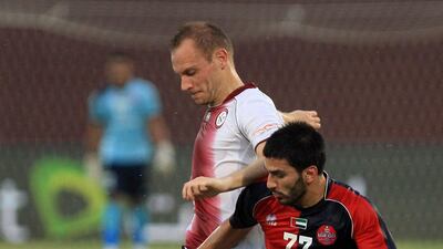 Al Wahda's Srdan Andric, in white and Al Shaab's Hassan Maatouk tussle for the ball. Ravindranath K / The National
