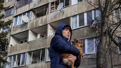 A resident with her dog near her apartment building, which was damaged during a Russian missile strike in Lviv, Ukraine. Reuters