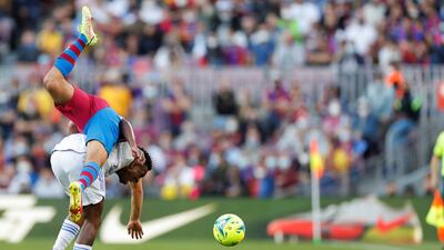 Barcelona defender Sergino Dest goes tumbling after a clash with Real Madrid winger Vinicius Jr. EPA