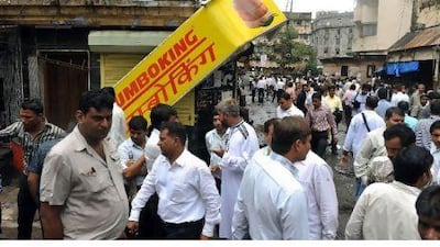 Diamond traders and office workers gather near the site of the bomb blast at Opera House in Mumbai yesterday. Scores of diamonds have been found on the devastated streets of Mumbai's precious stone trading hub which was targeted in last week's triple bombing, an industry group said. Teams of workers found the stones after picking through the debris and panning muddy monsoon puddles. Indranil Mukherjee / AFP Photo