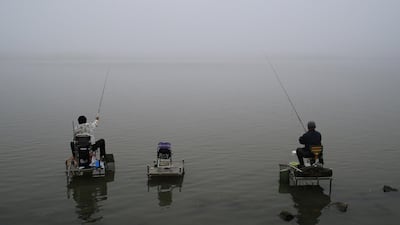 People fish on the banks of the Songhua River on a foggy day in Harbin, Heilongjiang province, China June 22, 2017. REUTERS/Stringer ATTENTION EDITORS - THIS IMAGE WAS PROVIDED BY A THIRD PARTY. CHINA OUT. NO COMMERCIAL OR EDITORIAL SALES IN CHINA.