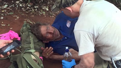 Reg Foggerdy, 62, who disappeared on October 7, is comforted by police trackers after finding him on October 13. Mr Foggerdy survived his six-day ordeal by eating black ants, police said. Western Australian Police / AFP Photo