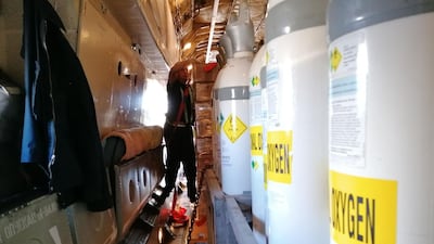 A crew member straps in the cargo of medical oxygen and ventilators on a plane bound for Delhi, India, at Helsinki airport. AFP