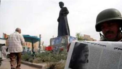 An Iraqi soldier reads a newspaper featuring Barack Obama on Wednesday.