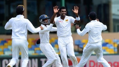 Dhammika Prasad, centre, celebrates with teammates after he dismissed Lokesh Rahul during the opening day of their third and final Test in Colombo. Lakruwan Wanniarachchi / AFP
