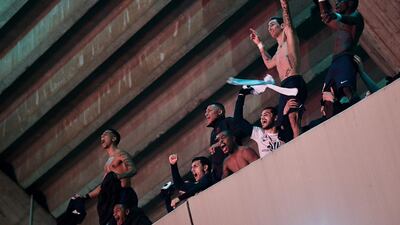 PSG players celebrate on the top tier of the stadium as fans gather below. AFP