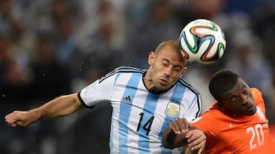 Argentina's midfielder Javier Mascherano, left, heads the ball past Netherlands' midfielder Georginio Wijnaldum during the semi-final football match between Netherlands and Argentina at The Corinthians Arena in Sao Paulo on July 9, 2014. PEDRO UGARTE / AFP