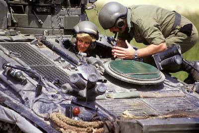 Diana, Princess of Wales, in the driving seat of a tank, receiving instructions from Sgt Chris O'Byrne on Salisbury Plain in 1998. PA
