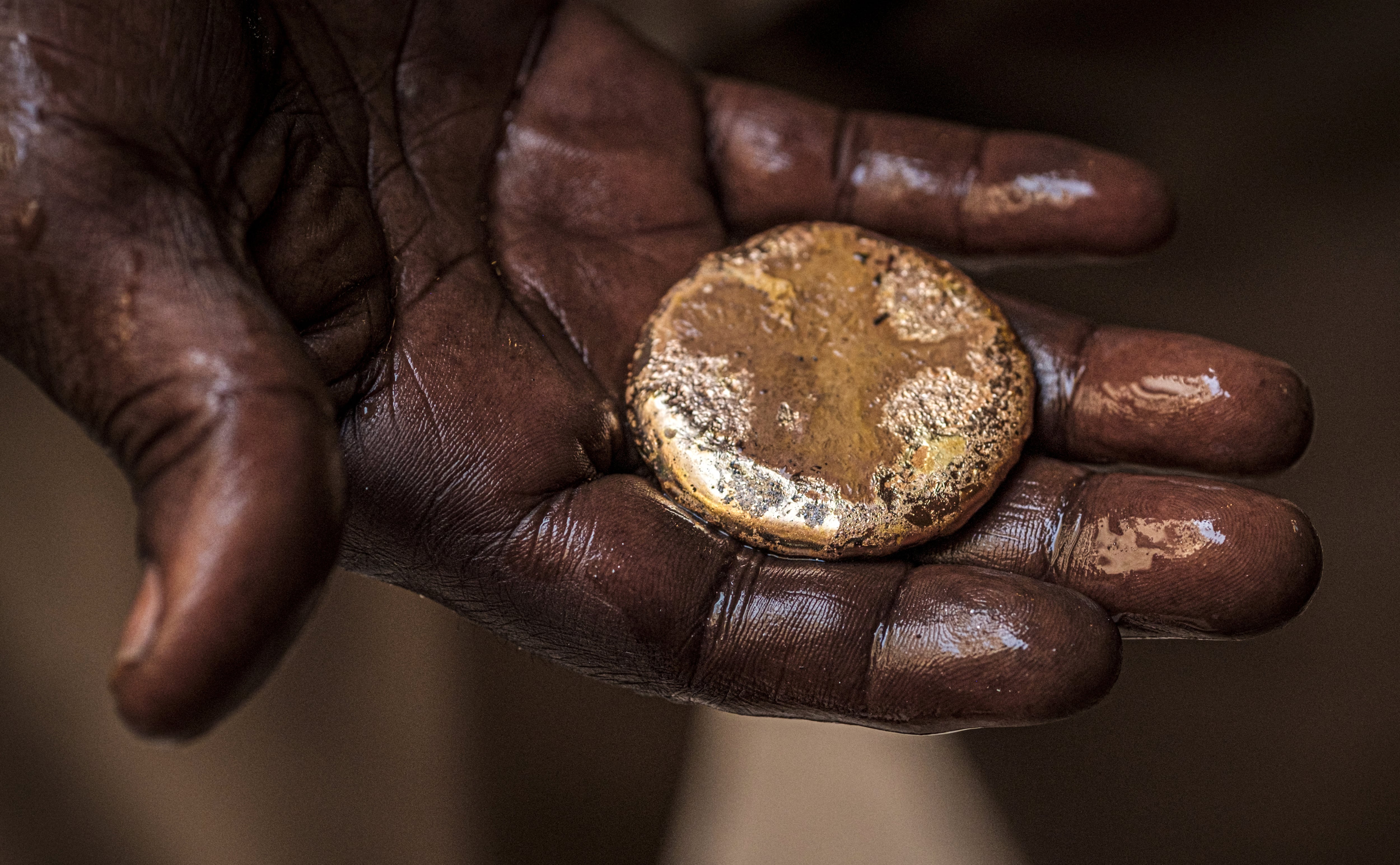 A craftsman holds a piece of gold at the gold market in Khartoum. AFP