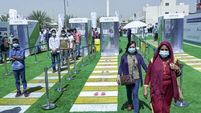 Workers and residents queue in front of the sanitising gate before they can enter the main tent screening centre.