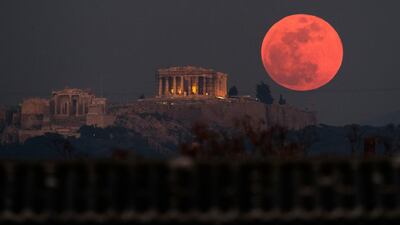 The super blue blood moon rises behind the 2,500-year-old Parthenon temple on the Acropolis of Athens, Greece. Petros Giannakouris / AP Photo.