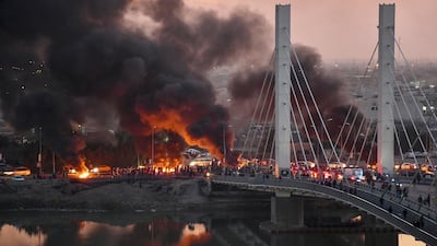 Iraqi Anti-government demonstrators block a bridge with debris and burning tires in the southern Iraqi city of Nasiriyah. AFP