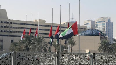 Flags fly at half mast at the Abu Dhabi Municipality office to mourn the five Emiratis killed in a bombing in Kandaha on Tuesday. Ravindranath K / The National