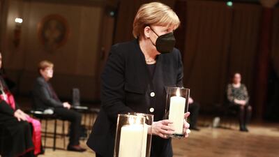 German Chancellor Angela Merkel holds a candle during a commemoration ceremony for Germany's coronavirus victims at Gendarmenmarkt concert hall on a national day of mourning on April 18, 2021 in Berlin, Germany. Getty Images