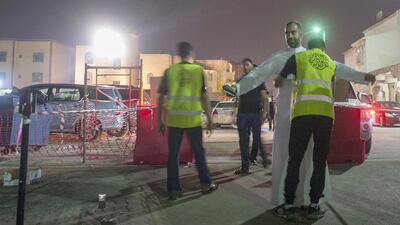 Saudi Shiite worshipers frisked by members of security as they make their way to a hussainiya in the mainly Shiite coastal town of Qatif. Hussein Radwan / AFP