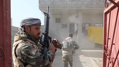 Soldiers prepare to search a house damaged during clashes with ISIL fighters.