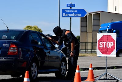 A member of the Catalan regional police force Mossos d'Esquadra controls a checkpoint on the road leading to Lleida AFP