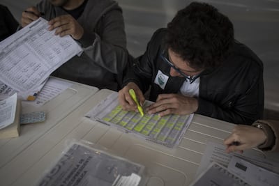 Polling officials verify a voter's identification inside a polling station during presidential elections in Bogota, Colombia, on Sunday, May 27, 2018. Nicolo Filippo Rosso/Bloomberg