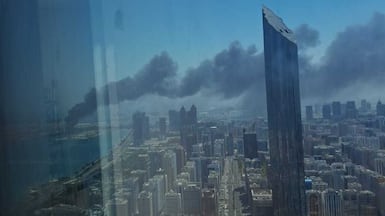 Black smoke rises from Mina Zayed, where emergency teams have contained the blaze
