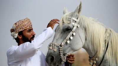 A rider makes final preparations to his horse before performing. Getty