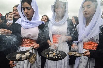 Iraqi Yazidis take part in a ceremony during the exhumation of a mass-grave of hundreds of Yazidis killed by ISIS in the northern Iraqi village of Kojo in Sinjar. AFP / Zaid AL-OBEIDI
