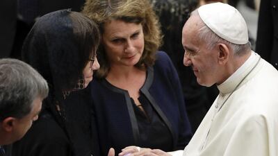 Pope Francis blesses a photo he is shown on a smartphone during a meeting with relatives of Nice's attack victims during a special audience in the Vatican, Saturday, Sept. 24, 2016. Andrew Medichini / AP