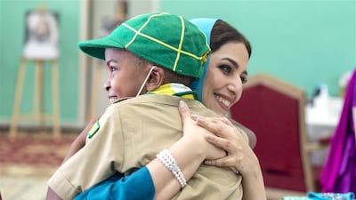 Ahad Al Busaidiyah, wife of Oman's Sultan Haitham, hugs a child during her visit to a centre for orphans in the country's Al Sib governorate. Photo: Oman News Agency