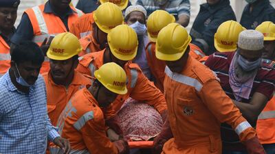 Indian rescue workers carry a victim's body from the building collapse site in Mumbai. Punit Paranjpe / AFP Photo