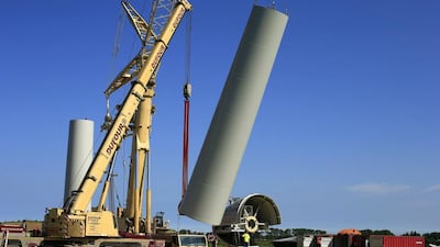 A crane lifts a tower section of an E-70 wind turbine during its installation at a wind farm in Meneslies. France aims to more than double the percentage of renewable energy used in the overall energy scheme to 32 per cent from 12 per cent. Benoit Tessier / Reuters