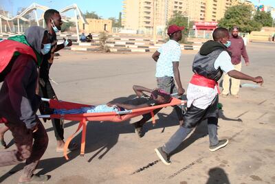 Sudanese protesters carry a wounded youth on a stretcher during demonstrations against the October 25 coup, in the capital Khartoum, on January 2, 2022. AFP
